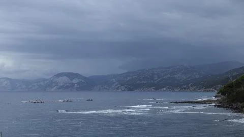 Turquoise wave and dramatic clouds on the coast, Mediterranean Sea, Sardinia Stock Photos