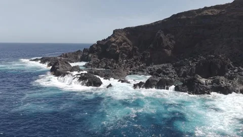 Turquoise waves breaking forcefully against black volcanic rocks along La Palma Video stock 308396549