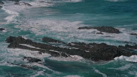 Turquoise waves breaking over dark rock reefs, Alentejo coast, Portugal Stock Footage 346479862