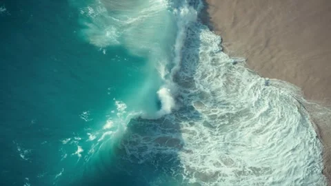 Turquoise waves breaking on a sandy beach in aerial slow motion Stock Footage 341328819