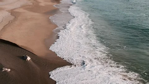 Turquoise waves gently breaking onto warm sandy shoreline. Stock Footage 328932936