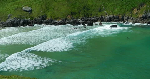 Turquoise waves gently crash onto a sandy shore, with. Stockbeeldmateriaal 343666812