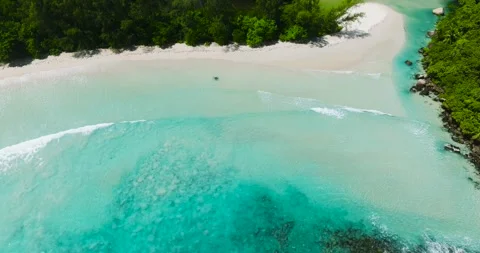 Turquoise waves gently lapping against a pristine sandy shore. Seychelles, Mahe. Stock Footage 321914167