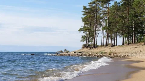 Turquoise waves roll onto the sandy shore of Lake Baikal. Video stock 293171664