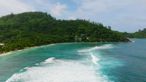 Turquoise waves rolling towards lush green coastline. Stock Footage 342833147