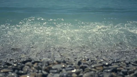 Turquoise waves run to the shore, covered with pebbles. HD, 1920x1080. slow Stock Footage 83343283
