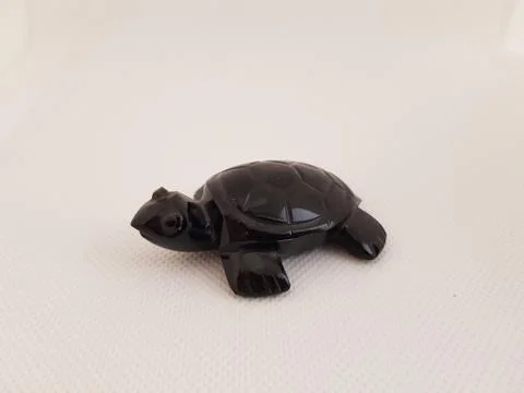 A turtle made of obsidian on a white background Stock Photos