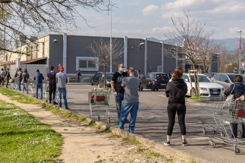 Tuscany, Italy - 03/21/2020: Coronavirus, lines people lined up at grocery store Stock Photos