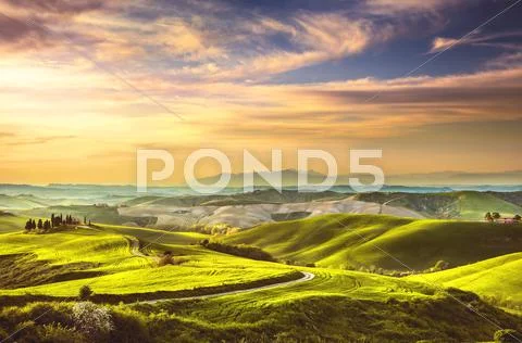 Tuscany spring, rolling hills on sunset. Rural landscape. Green fields and fa Stock Photos