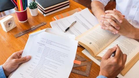 Tutor and college students teaching school work and explaining problem soluti Stock Photos