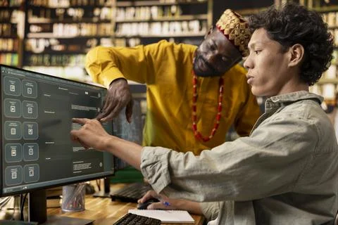 Tutor and student pointing at chatbot interface on desktop monitor Stock Photos