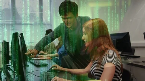 Tutor leaning over guiding student typing at monitor in computer lab, green Stock Footage 334337973