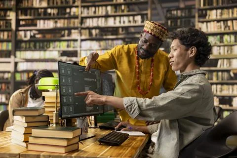 Tutor pointing at AI chatbot screen with asian student reviewing prompts Stock Photos