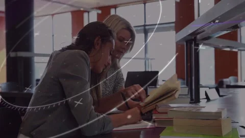 Tutor pointing to book at study table, student writing notes as graphics Stock Footage 328265574