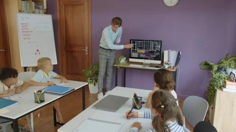Tutor Pointing at Monitor during Coding Lesson with Schoolchildren 動画素材 280539356