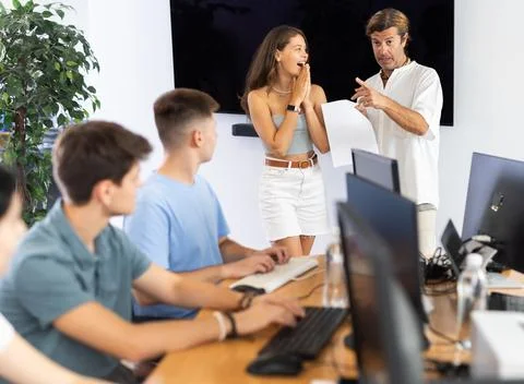 Tutor presenting diploma of completion of computer courses to satisfied girl Foto stock