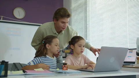 Tutor Showing Small Students How to Do Programming Task on Laptop Stock Footage 280539351