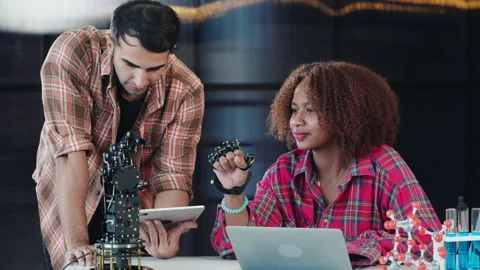 A tutor supports a student in building a robotic arm for design and technology Stock Footage 272567692