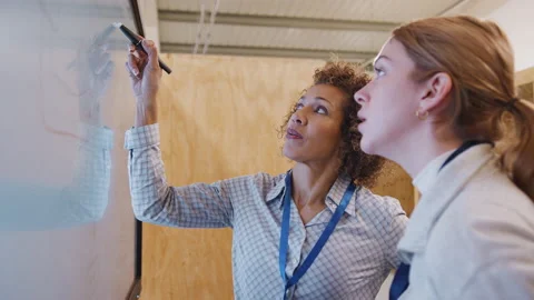 Tutor With Trainee Electrician Studying For Apprenticeship Looking At Wiring Stock Footage 130614093