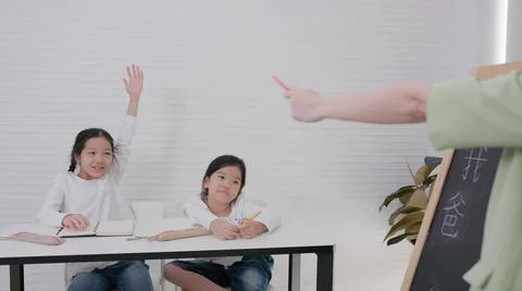 In tutorial school, Asian students learn to write in both English and Chinese Foto stock
