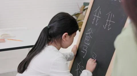 In tutorial school, Asian students learn to write in both English and Chinese 写真素材