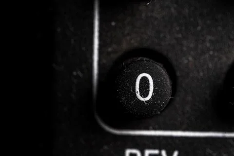 Tv 0 icon and button close up of a old dusty black Television remote controll Stock Photos