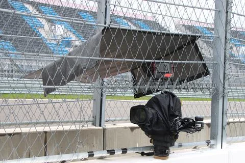 TV camera broadcasting live a race at motor racing track. Stock Photos