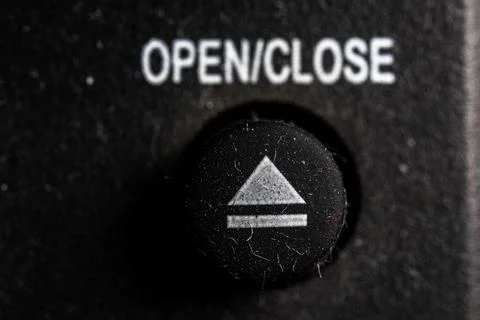 Tv eject icon and button close up of a old dusty black Television remote co.. Stock Photos