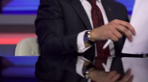 The TV Host Corrects Papers On a Table Before Broadcast Stock Footage 68293715