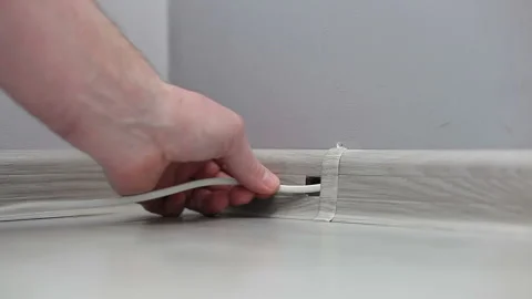 A TV man lays a cable in a plinth box. Laying the cable in the plinth Stock Footage 239621270
