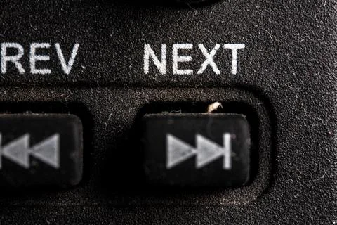 Tv next icon and button close up of a old dusty black Television remote con.. Stock Photos