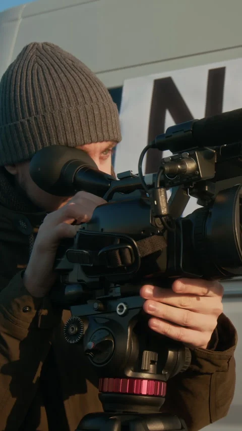 TV Operator Filming News Report on Camera next to Production Truck Stock Footage 300800078