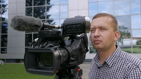 The TV operator removes the video with a professional video camera, which stands Stock Footage