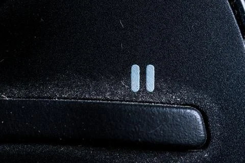 Tv pause icon and button close up of a old black Television remote controller Stock Photos