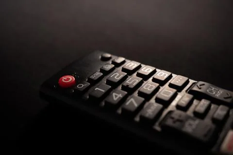 TV power button on the remote control on black background Stock Photos