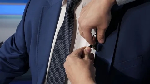 A TV presenter is dressed in a microphone in front of a live broadcast. News. Stock Footage 124522640