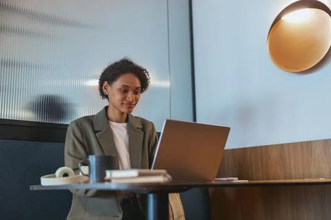 TV presenter using laptop at table in building event, with fun display device Stock Photos