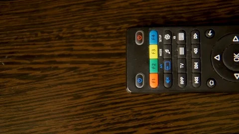 The TV remote on a brown table Vídeos de archivo 104369247
