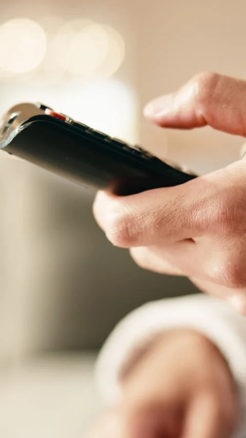 TV remote, choice and hand of person in home for volume, media selection or Stock Footage 343631868
