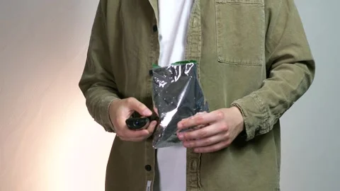 TV remote control and a pack of chips in a mans hands. Mens hands press the TV Stock Footage 312670486