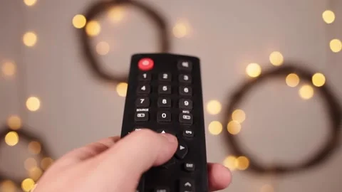 TV remote control closeup Fingers press buttons Boke and yellow Stock Footage 146448975