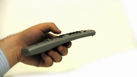 TV remote control closeup, Fingers press buttons against White background. Stock Footage 257874865