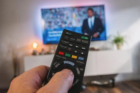 TV remote control, the hand with a remote control, pov view Stock Photos