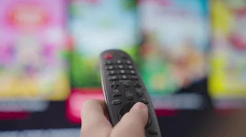 TV remote control, smart home appliances, button press program, select movies on Stock Photos
