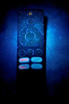 TV Remote Control Under UV Light Revealing Dust Germs and Fluorescent Buttons Stock Photos