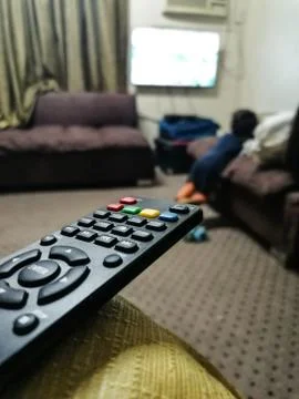 TV remote controller on sofa at home Stock Photos