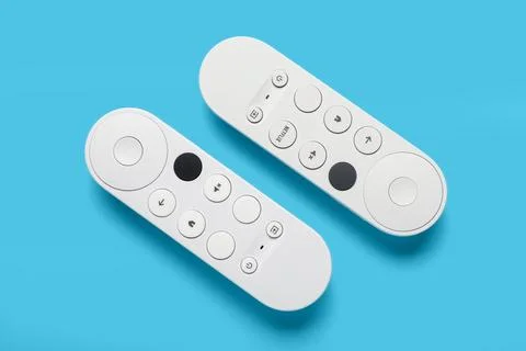 TV remote controllers on blue background 库存照片
