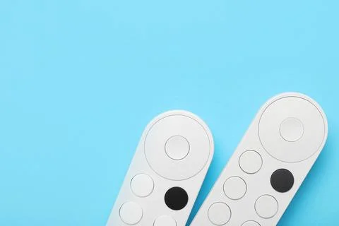 TV remote controllers on blue background 库存照片