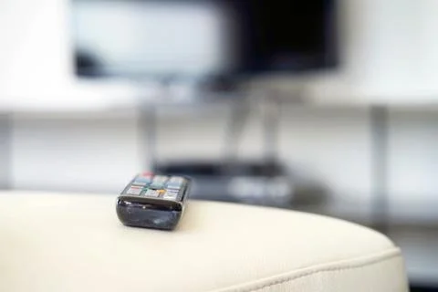 TV remote on the couch. Stock Photos