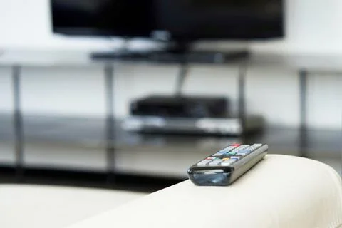 TV remote on the couch. Stock Photos